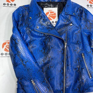 May include: A bright blue motorcycle jacket featuring a black snakeskin pattern, a notched collar, silver-tone metal zippers on the front and sleeves, and a black interior lining. A white label with the text ana plus is visible at the neck.