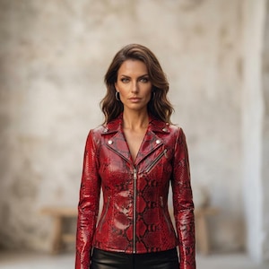 May include: A red and black snakeskin-patterned leather jacket featuring a notched lapel, silver-tone metal zippers on the front and pockets, and snap button details on the collar. The jacket is worn with black trousers.