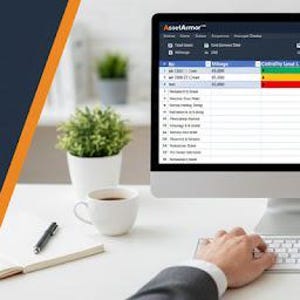 Könnte beinhalten: Ein Desktop-Computer, ein Laptop und ein Smartphone zeigen eine Oberfläche zur Flottenwartung. Der Text "AssetArmor" und "FLEET MAINTENANCE TRACKER" sind sichtbar. Das Bild enthält auch eine Tasse Kaffee, einen Stift und eine kleine Pflanze.