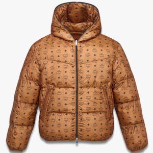 May include: Brown puffer jacket with a hood and a full-length zipper. The jacket features a repeating pattern of black logos. The jacket has two side pockets and a black lining around the hood.