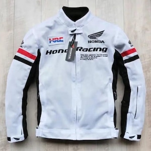 Może przedstawiać: Biała kurtka Honda Racing z czarnymi i czerwonymi akcentami. Posiada logo Honda i naszywkę HRC. Kurtka ma stójkę i zamek błyskawiczny. Rękawy mają czarno-czerwone paski. Dołączona jest metka z logo Honda.