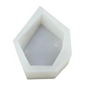 Può includere: Uno stampo in silicone bianco, geometrico, a forma di pentagono. L'interno è di colore grigio chiaro. Lo stampo ha pareti spesse e una superficie liscia, ideale per la creazione di resina o altri progetti fai-da-te.