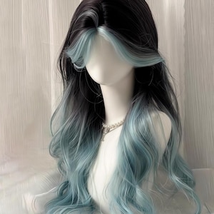 Puede incluir: Una peluca larga y ondulada con una base oscura que se desvanece en un tono azul verdoso. La peluca presenta un flequillo azul claro y está peinada sobre una cabeza de maniquí. El cabello tiene una onda de aspecto natural.