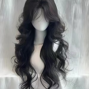 May include: A long, wavy black wig styled on a mannequin head. The wig features a layered cut with voluminous curls and a natural-looking hairline. A pearl necklace adorns the mannequin's neck, and the background is a soft, white curtain.