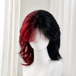 May include: A shoulder-length wig featuring a split-color design with vibrant red hair on the left side and solid black hair on the right side. The wig has layered, textured strands, a side-swept fringe, and a natural-looking center part.