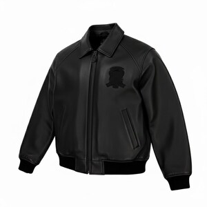 Puede incluir: Chaqueta bomber de cuero negro con cuello, cremallera frontal y un peque&ntilde;o emblema en el pecho. La chaqueta tiene pu&ntilde;os y dobladillo de canal&eacute; negros.