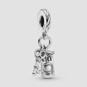 May include: A silver charm with a key and a door knocker design. The charm hangs from a decorative loop and is made of shiny metal. The key has a detailed handle, and the door knocker has a face.