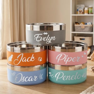 Puede incluir: Una pila de cinco cuencos de acero inoxidable para mascotas con exteriores mate de colores. Los cuencos están personalizados con nombres en letra cursiva blanca: Evelyn, Jack, Piper, Oscar y Penelo, acompañados de pequeños iconos como una corona, un gato, una huella, corazones y plantas.