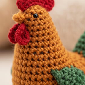 May include: A handmade crochet rooster in shades of orange, red, and green. The rooster has a red comb and wattle, with black eyes. The body is a textured orange, and the wings are green. This decorative item is a charming addition to any home.