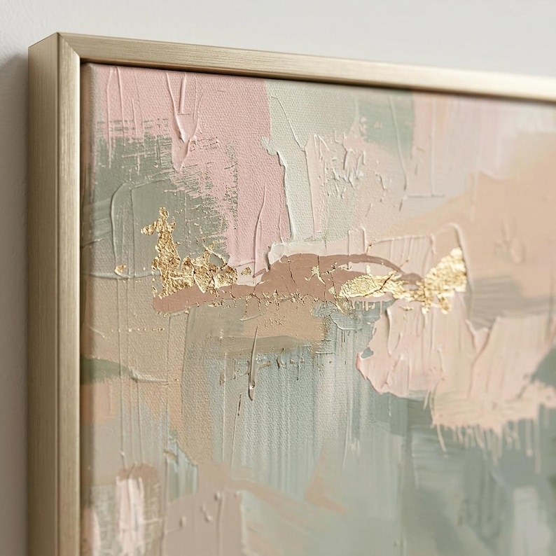 May include: Abstract art piece with a gold-toned frame. The canvas features a textured, layered design in soft pink, beige, and muted green hues, accented with gold leaf details. The artwork has a modern, minimalist aesthetic.