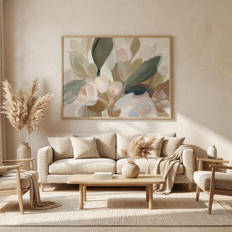 May include: A living room with a large abstract floral painting in a wooden frame above a beige sofa. The room includes wooden chairs, a coffee table, and vases with dried plants, creating a neutral and calming aesthetic.