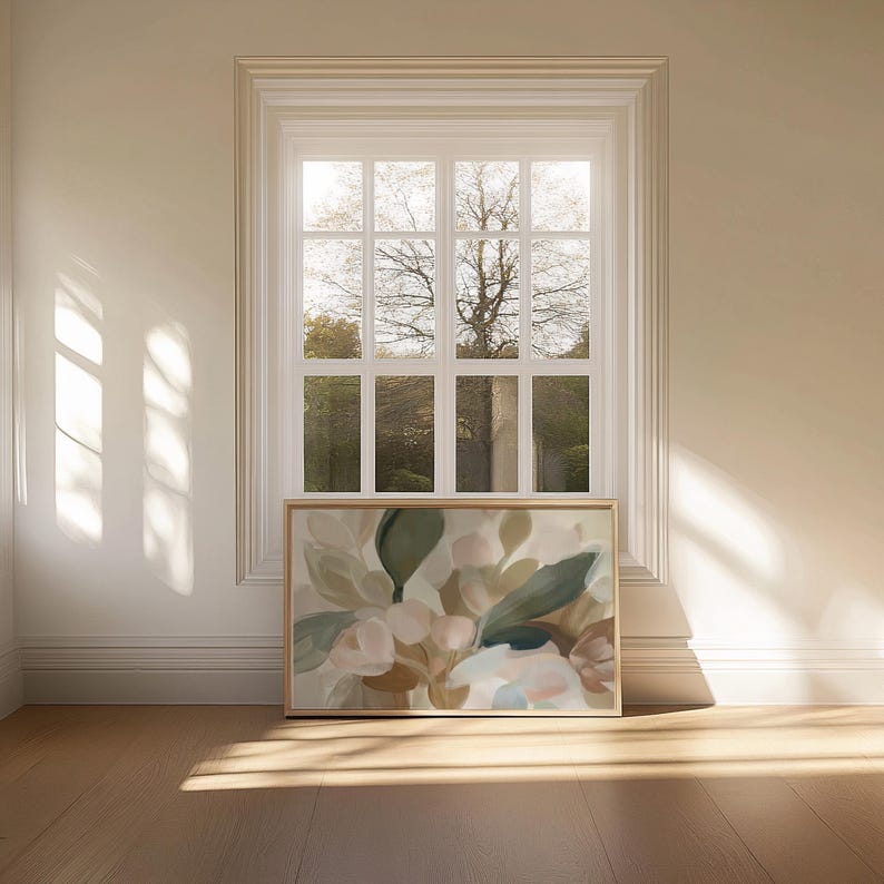 May include: A framed floral art print with a palette of beige, green, and pink. The artwork is displayed on a wooden floor in front of a window with natural light.