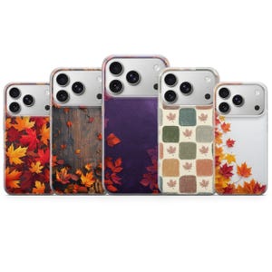 May include: Five smartphone cases arranged in a row, each featuring a distinct autumn-themed design. The patterns include vibrant red and orange maple leaves, a dark wood grain background, a deep purple gradient, a checkered grid, and a white border.