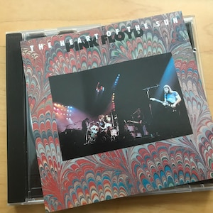 May include: A CD case with the album cover of Pink Floyd's "The Heart of the Sun." The cover features a live concert photo with the band performing on stage. The album art has a colorful, marbled design in red, blue, and white.