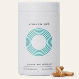 May include: A white cylindrical bottle labeled "WOMEN'S BALANCE" with a teal circular design. The bottle also says "HAIR GROWTH NUTRACEUTICAL" and "DIETARY SUPPLEMENT 120 CAPSULES". Several brown capsules are in front of the bottle.