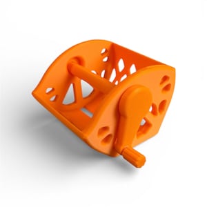 Puede incluir: Un ovillador de hilo naranja brillante con manivela. El ovillador tiene forma de cesta rectangular con diseños geométricos recortados. Un asa está unida a la parte superior y una manivela en el lateral para enrollar el hilo.