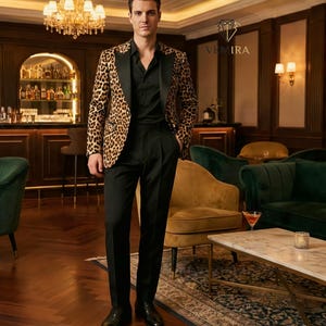 May include: A man wearing a leopard print blazer with black lapels, a black shirt, and black trousers. The blazer has a brown and black spotted pattern. The outfit is completed with black dress shoes. The background includes a bar and seating area.