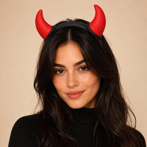 Può includere: Un cerchietto nero con due corna da diavolo rosse, lisce e ricurve, rivolte verso l'alto. Le corna sono di colore solido con una finitura opaca e sono fissate saldamente alla parte superiore della sottile e flessibile struttura in plastica nera.