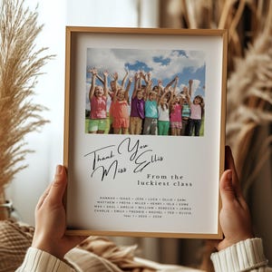 Puede incluir: Un marco con una foto de niños con los brazos levantados. La impresión contiene el texto "Thank You Miss Ellis From the luckiest class" y una lista de nombres. El marco es de color marrón claro.