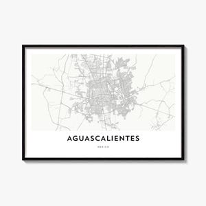May include: A framed wall art print featuring a detailed grey and white street map of Aguascalientes, Mexico. The print includes the text AGUASCALIENTES in bold black capital letters, with the word MEXICO printed in smaller text underneath.