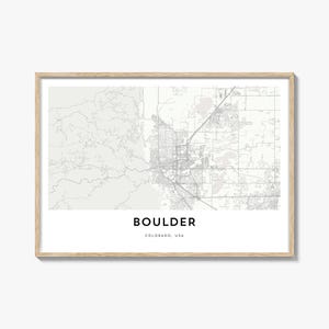 Può includere: Una stampa incorniciata della mappa di Boulder, Colorado, USA. La mappa è in scala di grigi, che mostra la disposizione della città con strade e caratteristiche geografiche. La parola "BOULDER" è stampata in grassetto, in nero, con "COLORADO, USA" sotto.