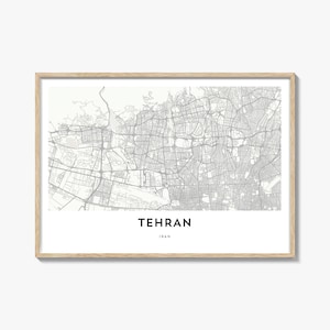 May include: A framed print featuring a detailed map of Tehran, Iran, in shades of gray. The city's name is displayed in a bold font at the bottom, with "Iran" below it. The frame is a light wood color.