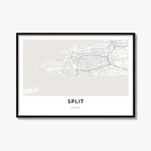 May include: A framed wall art print featuring a light beige map of Split, Croatia, with grey street lines. The text SPLIT is printed in bold black capital letters above the word CROATIA in smaller black capital letters at the bottom center.