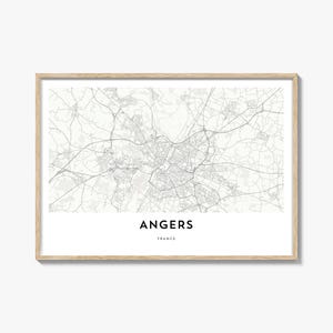 May include: A framed print featuring a grayscale map of Angers, France. The map shows the city's infrastructure, including roads and buildings. The city name "ANGERS" and country "FRANCE" are printed in a modern font below the map.