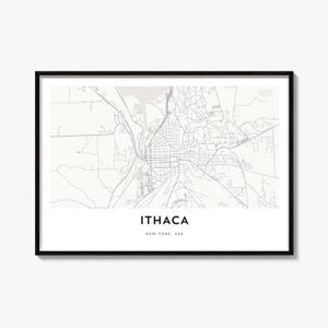 May include: A framed wall art print featuring a light gray street map of Ithaca, New York, USA. The map displays a grid of roads and geographical features on a white background. Below the map, the text reads ITHACA and NEW YORK, USA.