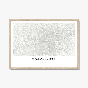 Könnte beinhalten: Gerahmter Druck mit einer detaillierten, graustufigen Karte von Yogyakarta, Indonesien. Der Name der Stadt steht in sauberer Schrift unter der Karte, darunter "Indonesien". Der Rahmen ist helles Holz.