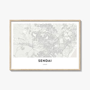 Puede incluir: Una impresión enmarcada que presenta un mapa detallado de Sendai, Japón, en tonos grises. El nombre de la ciudad se muestra en una fuente moderna y limpia debajo del mapa. El marco es de color madera clara, agregando un toque natural.