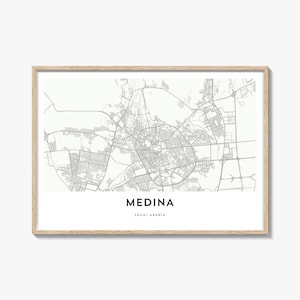 Può includere: Una stampa incorniciata di una mappa di Medina, Arabia Saudita, in scala di grigi. La mappa dettagliata della città mostra strade ed edifici. Il nome della città e il paese sono stampati in basso. La cornice è in legno chiaro.