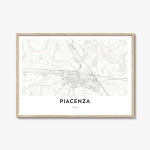 May include: A framed map print of Piacenza, Italy, in a minimalist style. The map is in grayscale, with the city's layout and surrounding areas detailed. The city name and country are printed in a clean font below the map.