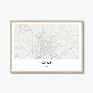 Könnte beinhalten: Eine gerahmte Graustufenkarte von Graz, Österreich, mit dem Namen der Stadt und des Landes in einer klaren, modernen Schriftart. Die Karte zeigt die Straßen und geografischen Merkmale der Stadt vor einem weißen Hintergrund.