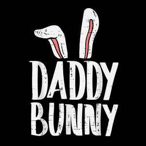 May include: A black graphic with the words "DADDY BUNNY" in distressed white font. Above the text are white bunny ears with pink inner ears. The design is likely for Easter or a similar holiday.