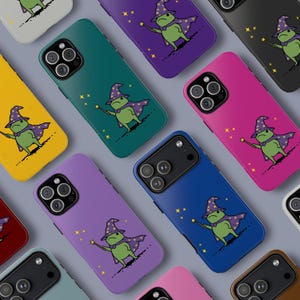 Puede incluir: Una colección de fundas de teléfono coloridas con un diseño de rana mago de dibujos animados. Las fundas vienen en varios colores, incluyendo amarillo, verde, morado, rosa y azul. La rana está representada con un sombrero de mago, capa y varita, con estrellas.