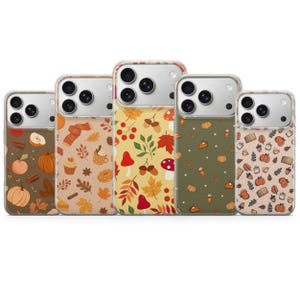 May include: Five clear smartphone cases featuring autumn-themed patterns. The designs include illustrations of pumpkins, acorns, mushrooms, leaves, coffee cups, and pastries in various color palettes including brown, beige, yellow, and olive green.