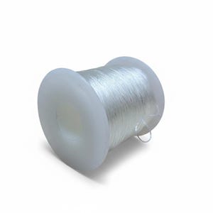 Op de afbeelding: Een witte plastic spoel met transparant, elastisch rijgdraad. De draad is strak om de spoel gewikkeld. De spoel is cilindrisch. De draad lijkt gemaakt van een transparant, flexibel materiaal.