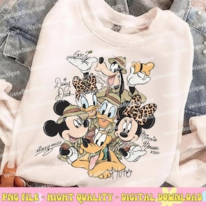 May include: White sweatshirt featuring a graphic of Disney characters Mickey Mouse, Minnie Mouse, Donald Duck, Daisy Duck, Goofy, and Pluto in safari outfits. The design includes the text "Mickey Mouse", "Minnie Mouse", "Daisy Duck", "Goofy", and "Pluto".