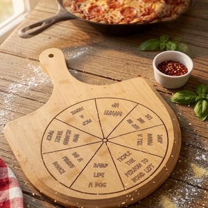 Puede incluir: Una pala de pizza de madera clara con un diseño de tablero de juego circular dividido en ocho segmentos. Cada segmento contiene instrucciones de texto: Wash up, Hop on one leg, Tell a funny joke, Tickle the person to your left, Bark like a dog, Do a funny dance, Spin around twice y Pick a movie.