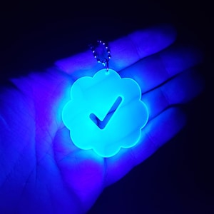 May include: A blue glow-in-the-dark keychain shaped like a cloud with a checkmark inside.