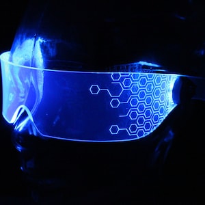 May include: Blue futuristic-style glasses with a hexagonal pattern on the lenses.