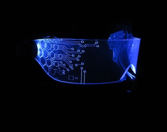 May include: A pair of blue-tinted glasses with a circuit board design on the lenses. The glasses are illuminated from the inside, creating a glowing effect.