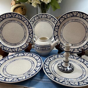 May include: A set of three ceramic mugs with a speckled, matte finish. The mugs are in shades of cream, light gray, and dark gray. Each mug has a simple, minimalist design and a rounded handle.