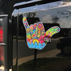 Bright detailed Shaka hand sticker on a black jeep door