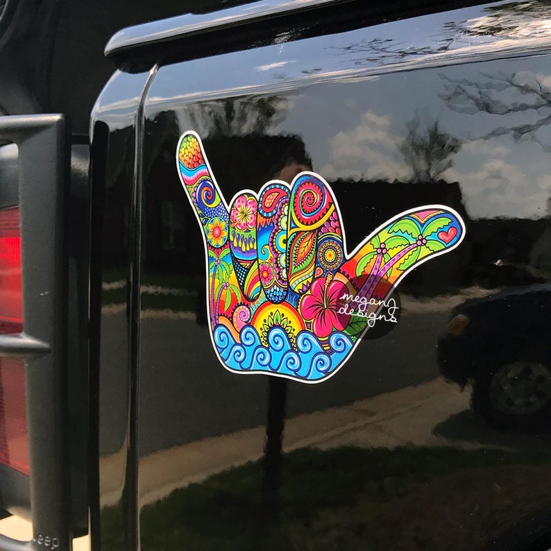 Bright detailed Shaka hand sticker on a black jeep door