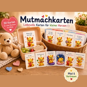 May include: A set of children's encouragement cards with a cartoon fox design, displayed in a basket and a container. The image includes a teddy bear and heart-shaped decorations. The text on the cards is in German.