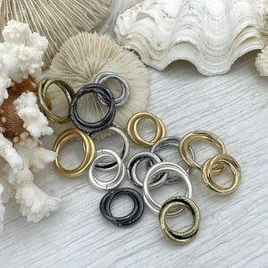 Könnte beinhalten: Eine weiße Keramik-Tasse mit schwarzem Henkel und dem Text "But First, Coffee" in schwarzer, fetter Schrift. Die Tasse steht auf einer weißen Oberfläche.