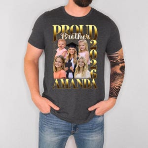 May include: Dark grey t-shirt with a gold foil design reading "Proud Brother 2026 Amanda." The design features a collage of six photos. The shirt is a crew neck with short sleeves.