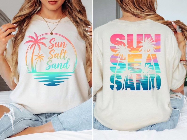K&ouml;nnte beinhalten: Cremefarbenes T-Shirt mit farbenfroher Grafik. Auf der Vorderseite sind eine Palme, die Worte "Sun Salt Sand" in einem Regenbogenbogen und eine t&uuml;rkisfarbene Wasserlinie abgebildet. Das Design auf der R&uuml;ckseite wiederholt das Thema mit den Worten "Sun Sea Sand".